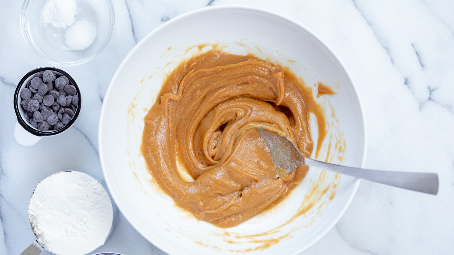 Wet ingredients mixed for Vegan Peanut butter Oatmeal Chocolate chip Cookies in a White Bowl