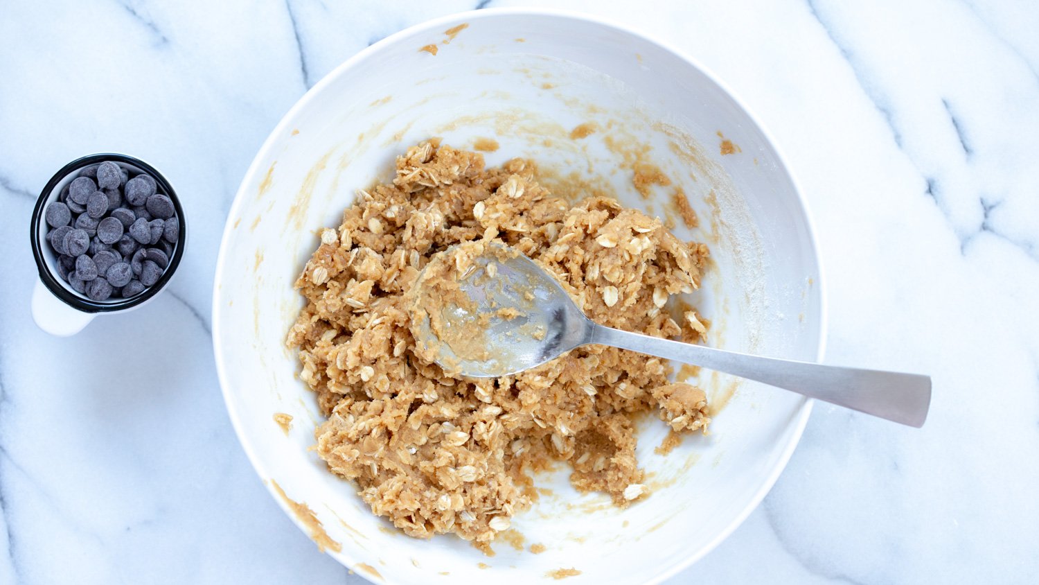 Dough of our Vegan Peanut butter Oatmeal Chocolate chip Cookies in a White Bowl