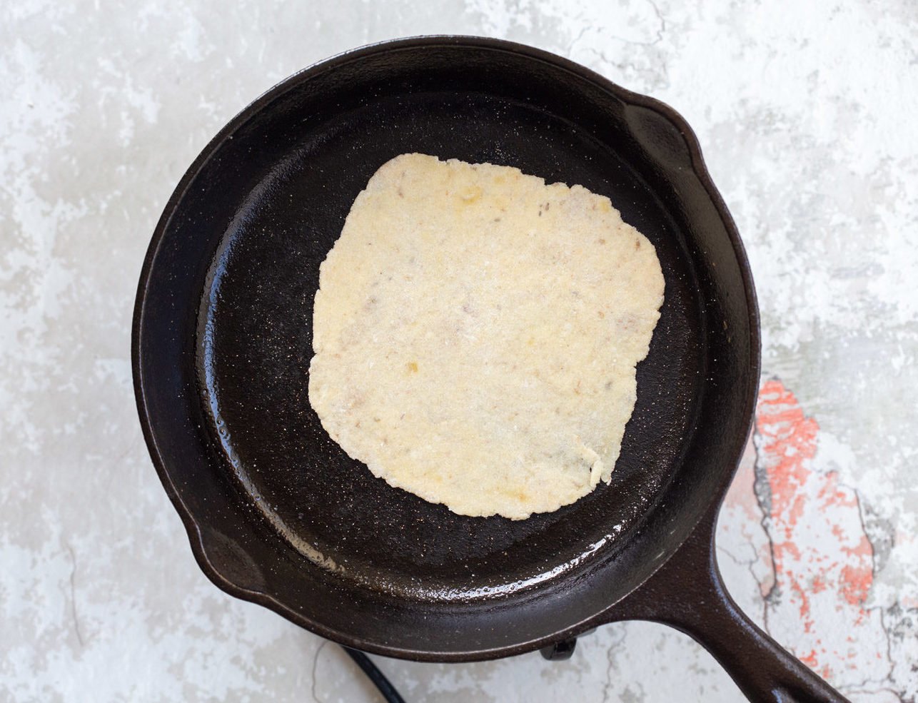 Gluten free Cauliflower Flatbread getting cooked on a cast iron skillet