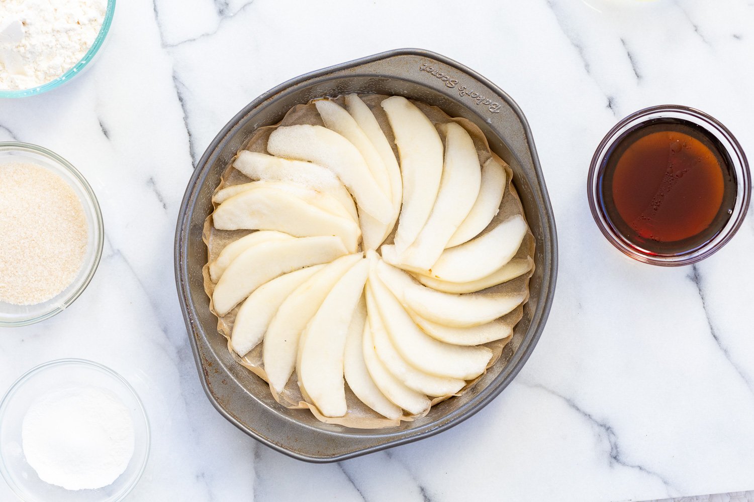 Pears arranged in a cake pan for Our Vegan Pear Upside Down Cake
