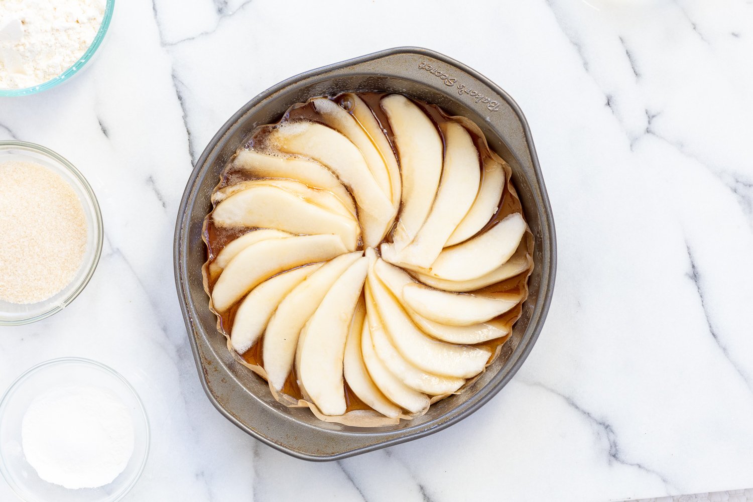 Pears arranged in a cake pan for Our Vegan Pear Upside Down Cake