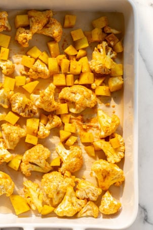 Our Vegan Baked Aloo Gobi - Potatoes and Cauliflower tossed in spiced and spread in a white baking dish