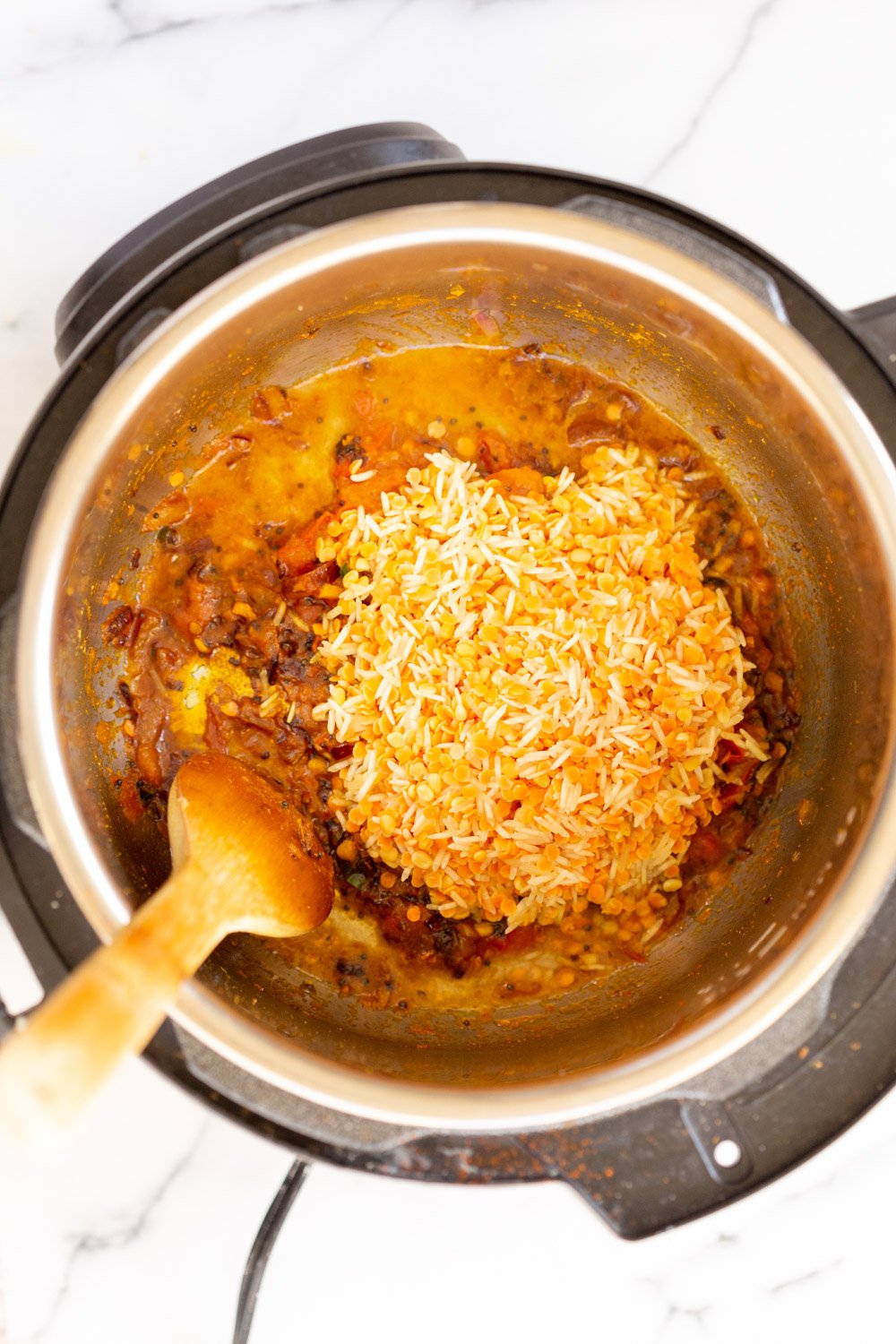 Instant Pot Kitchari  soaked rice and lentils being added to Instant Pot to make Kitchari