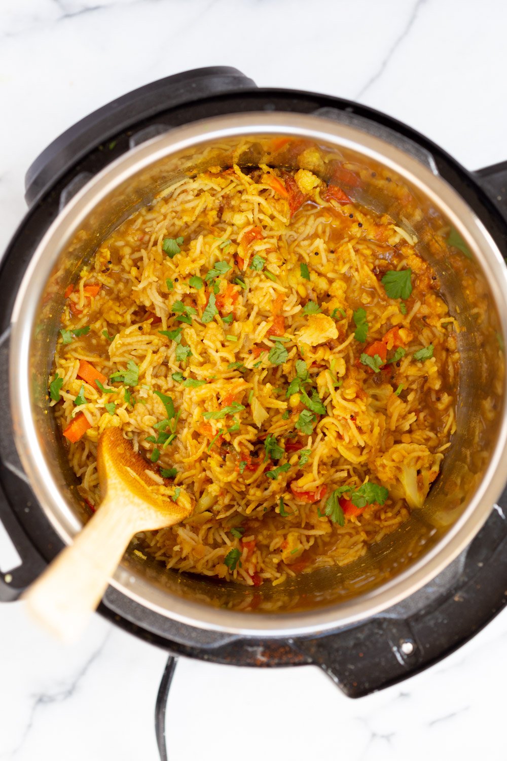 Instant Pot Kitchari  fresh cilantro being sprinkled on top of kitchari