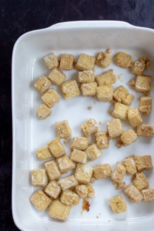 Baked Tofu cubes in a white baking dish for our Orange Tofu Recipe