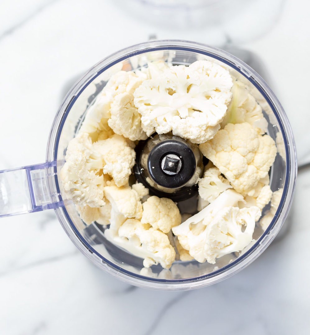 Cauliflower Florets in a Food Processor to be grated for Our Turmeric Cauliflower Rice