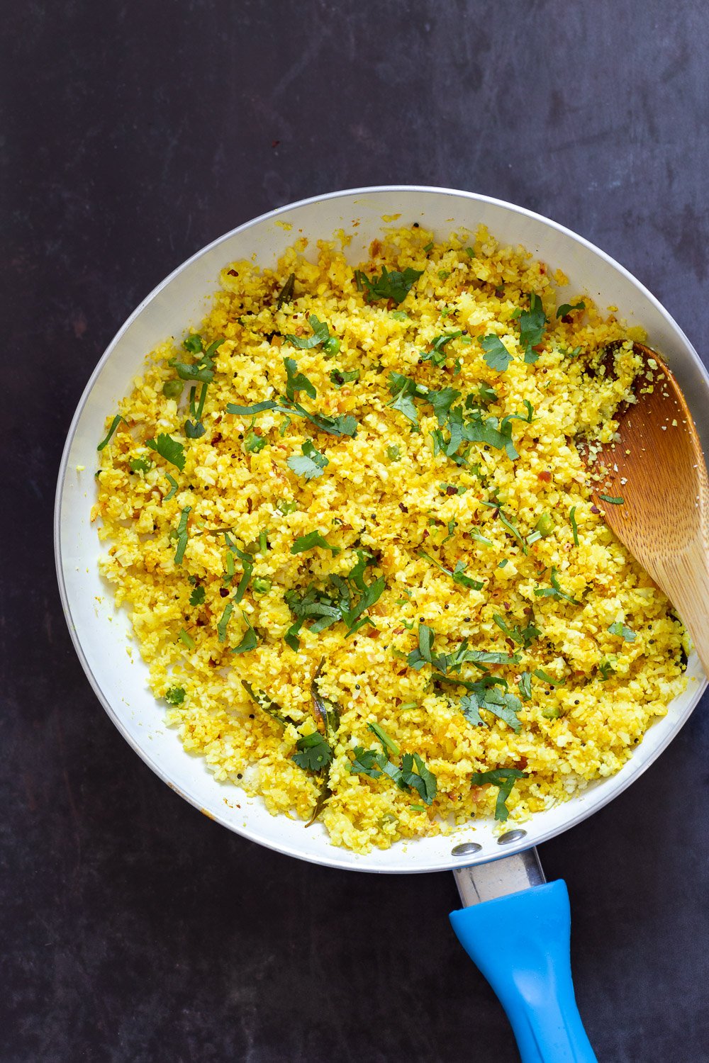 Lemony Turmeric Cauliflower Rice. Easy Side with any meal. 1 Pot Lemon Cauliflower Rice with mustard seeds and garlic in a White Skillet