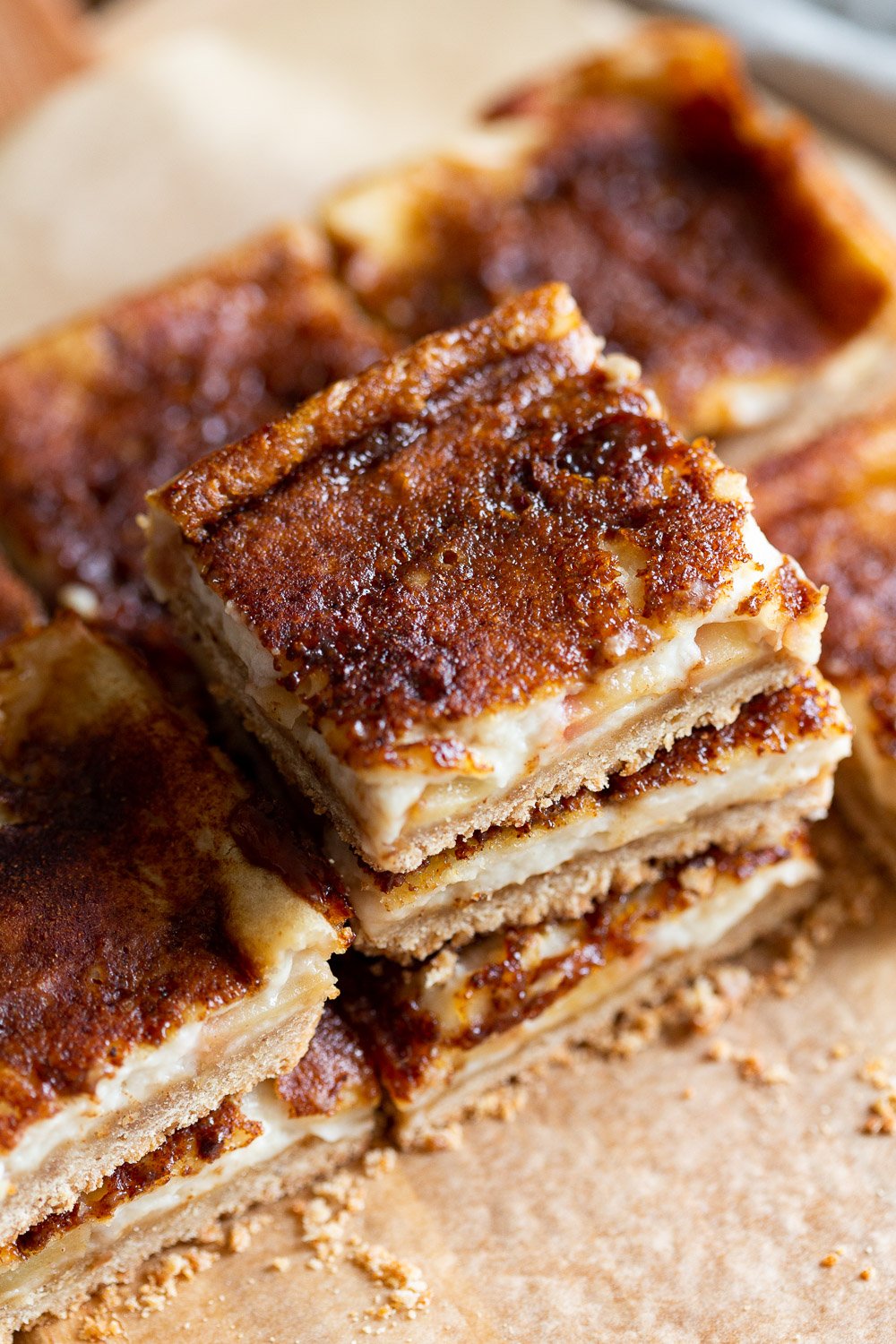 Sliced Vegan Apple Custard Squares stacked on wood board