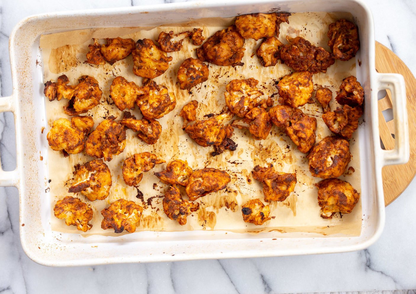 Our Vegan Nashville Hot Cauliflower Wings with hot sauce on white baking dish