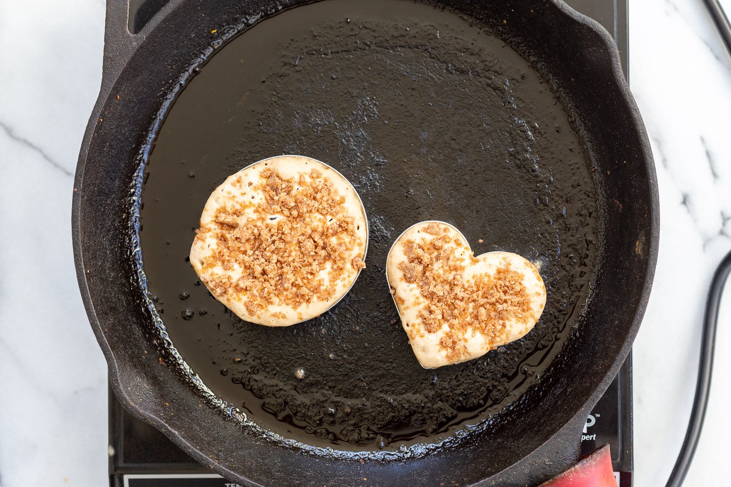 Vegan Cinnamon Streusel Pancakes getting cooked on a cast iron skillet