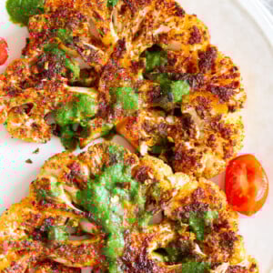 Vegan Cajun Roasted Cauliflower "Steaks" with Chimichurri Sauce. Slice into thick slices or just chop into florets to make this delicious Cajun Cauliflower. Serve with chimichurri or a cooling dressing. #Vegan #Glutenfree #Soyfree #Nutfree #Recipe #veganRicha #cajunCauliflower
