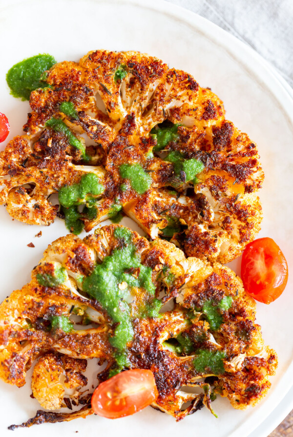 Vegan Cajun Roasted Cauliflower "Steaks" with Chimichurri Sauce. Slice into thick slices or just chop into florets to make this delicious Cajun Cauliflower. Serve with chimichurri or a cooling dressing. #Vegan #Glutenfree #Soyfree #Nutfree #Recipeย #veganRicha #cajunCauliflower
