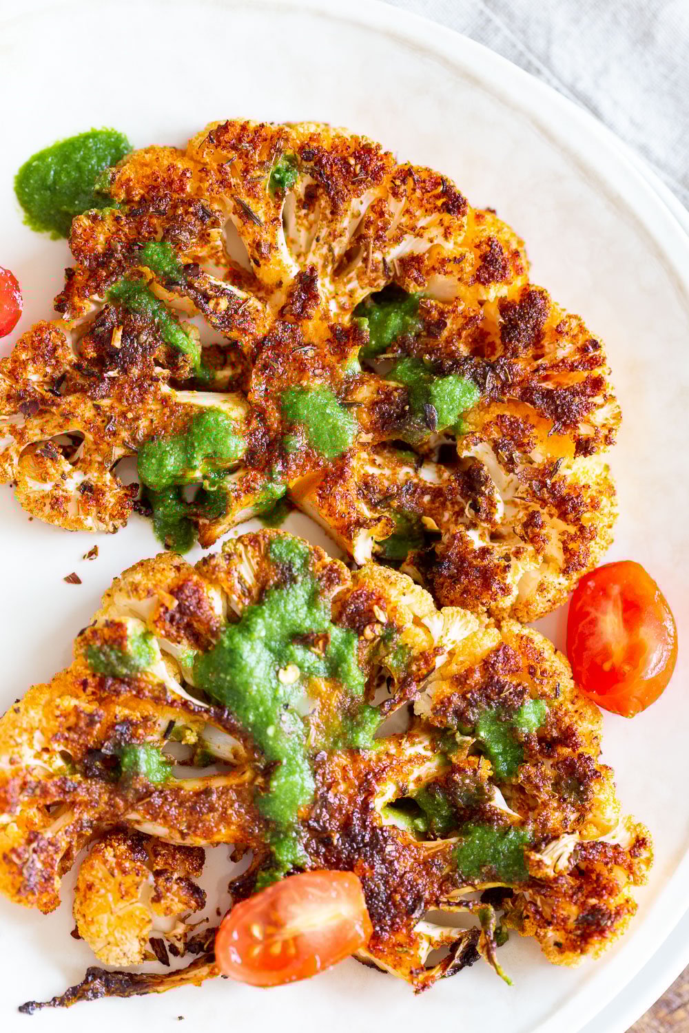 Vegan Cajun Roasted Cauliflower Steaks with Chimichurri Sauce. 30 Mins , Super Flavorful Slice into thick slices or just chop into florets to make this delicious Cajun Cauliflower. Serve with chimichurri or a cooling dressing. #Vegan #Glutenfree #Soyfree #Nutfree #Recipe #veganRicha #cajunCauliflower