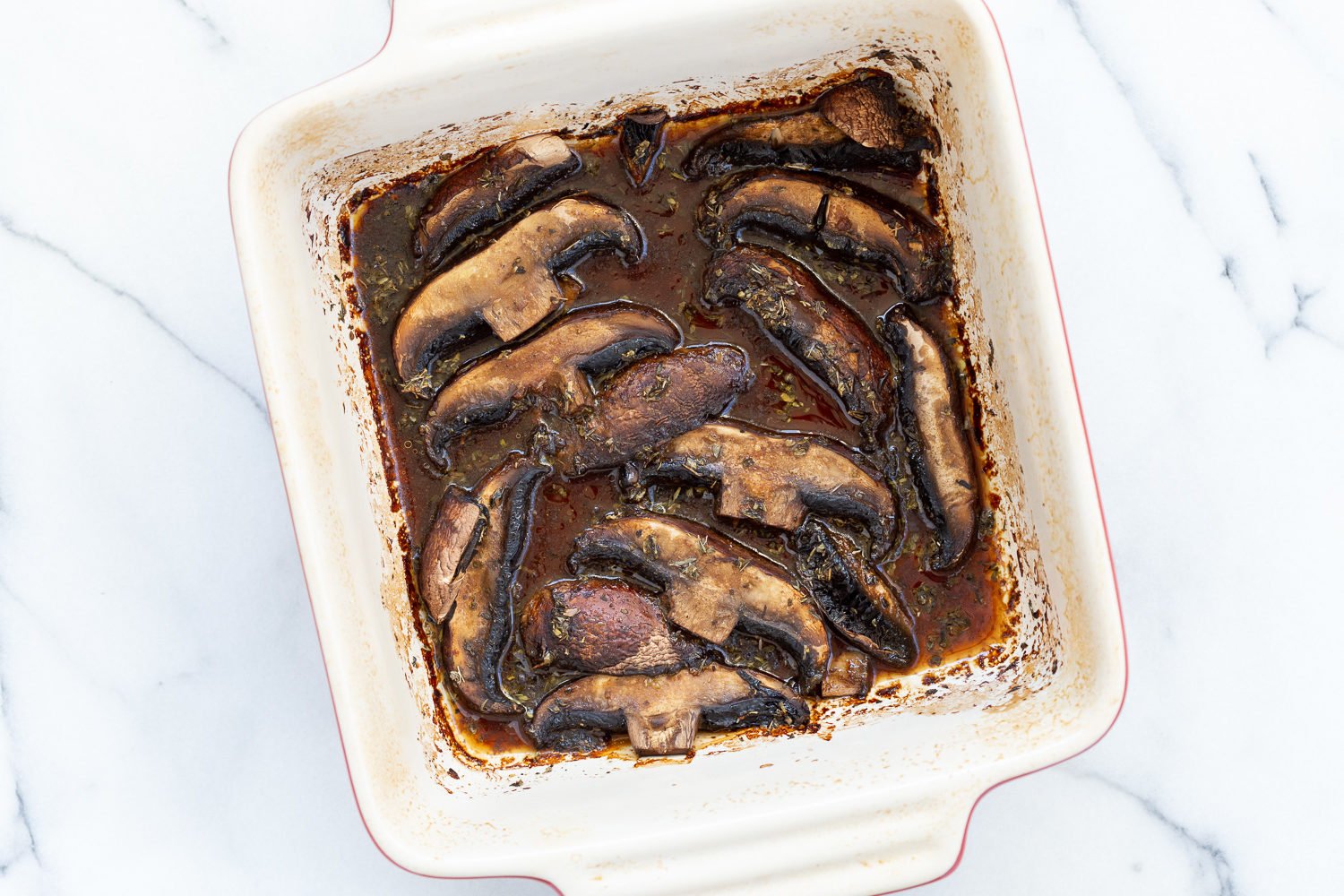Marinated and baked portobello mushrooms in a stoneware baking dish for Our Creamy Vegan Mushroom Lasagna