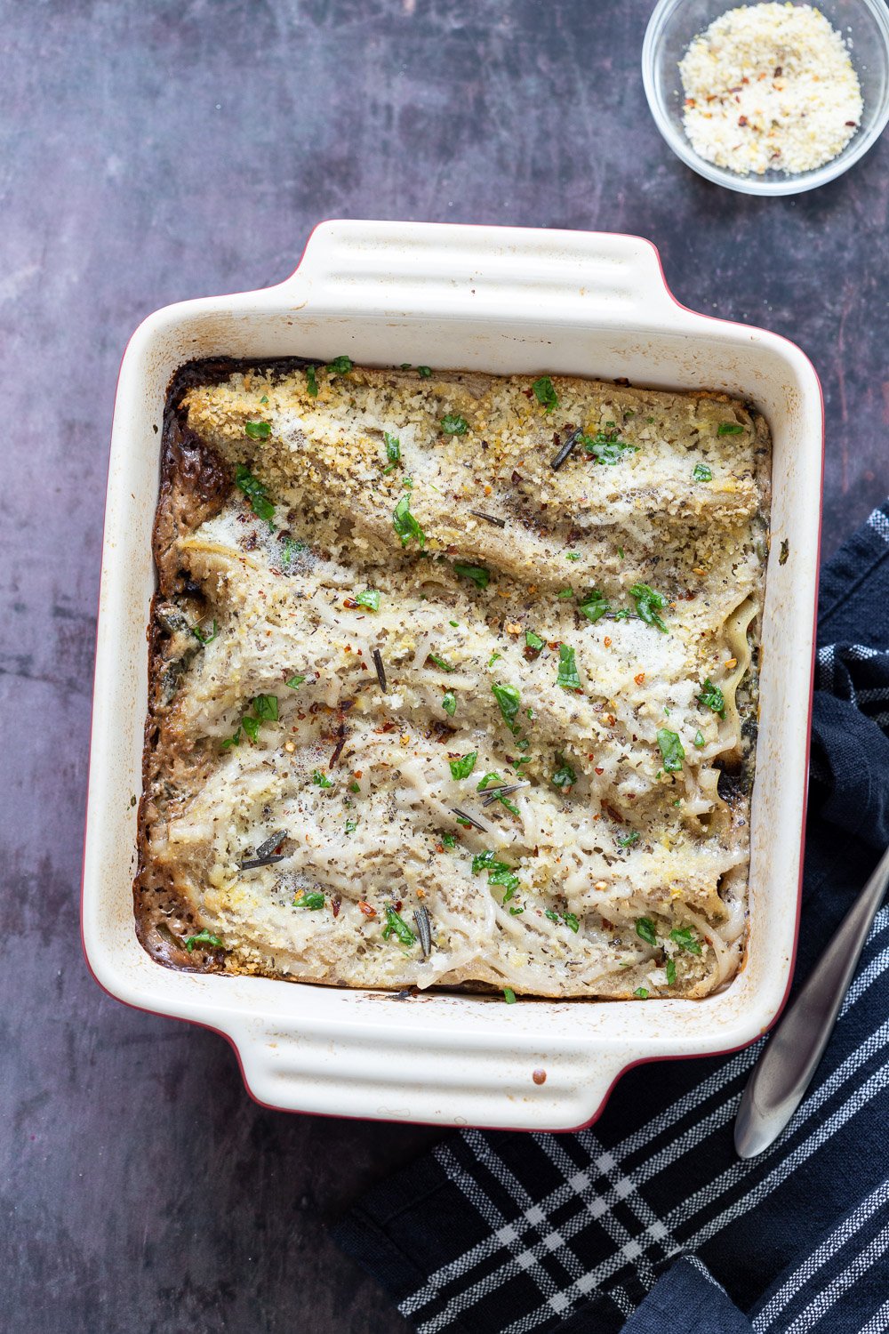 Our Creamy Vegan Mushroom Lasagna in a White and Red Stoneware dish