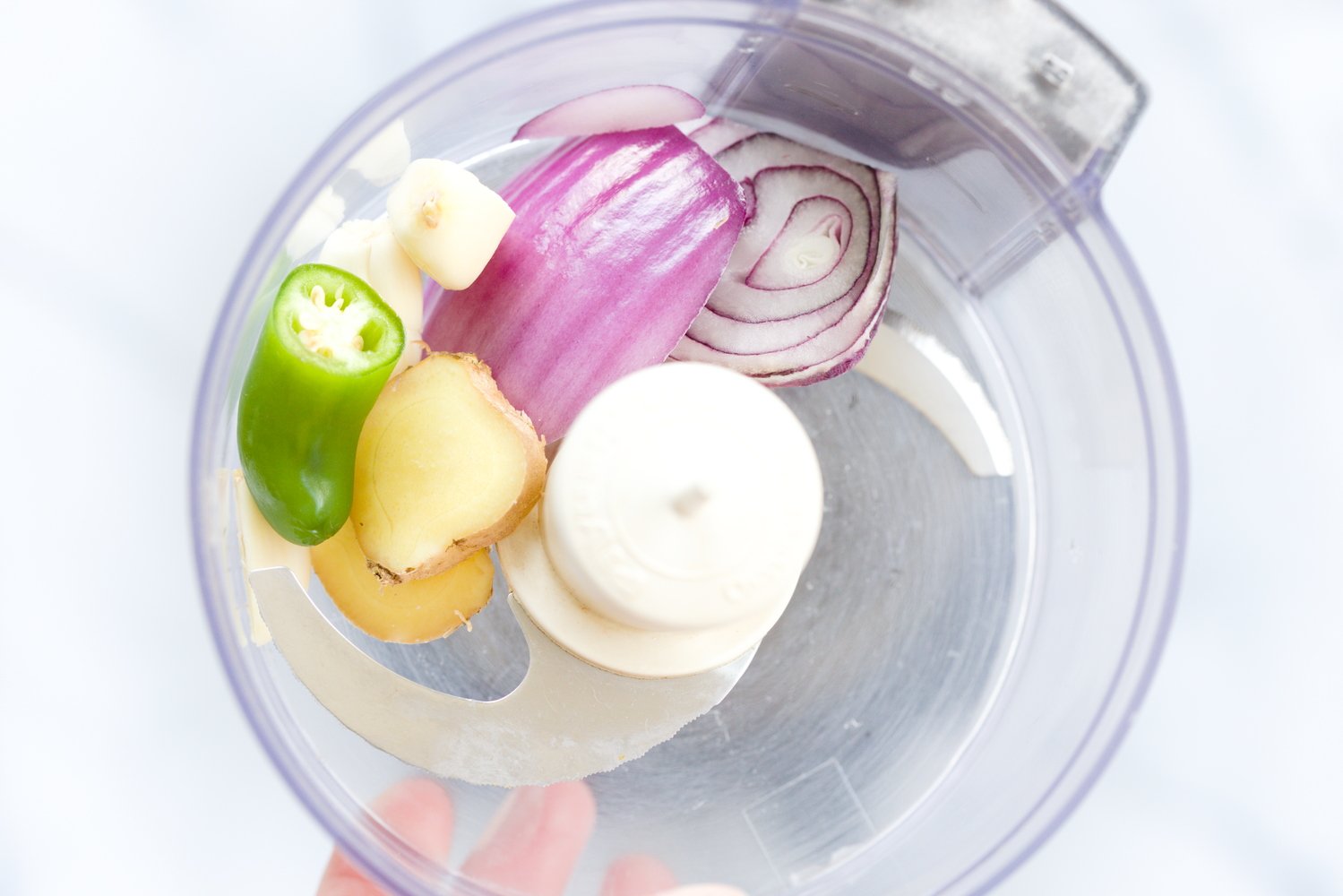 aloo matar ginger, red onion, garlic and green chili being chopped in a small food processor