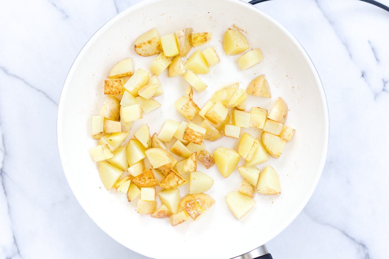 aloo matar overhead shot of sauteed potato cubes in a white bowl