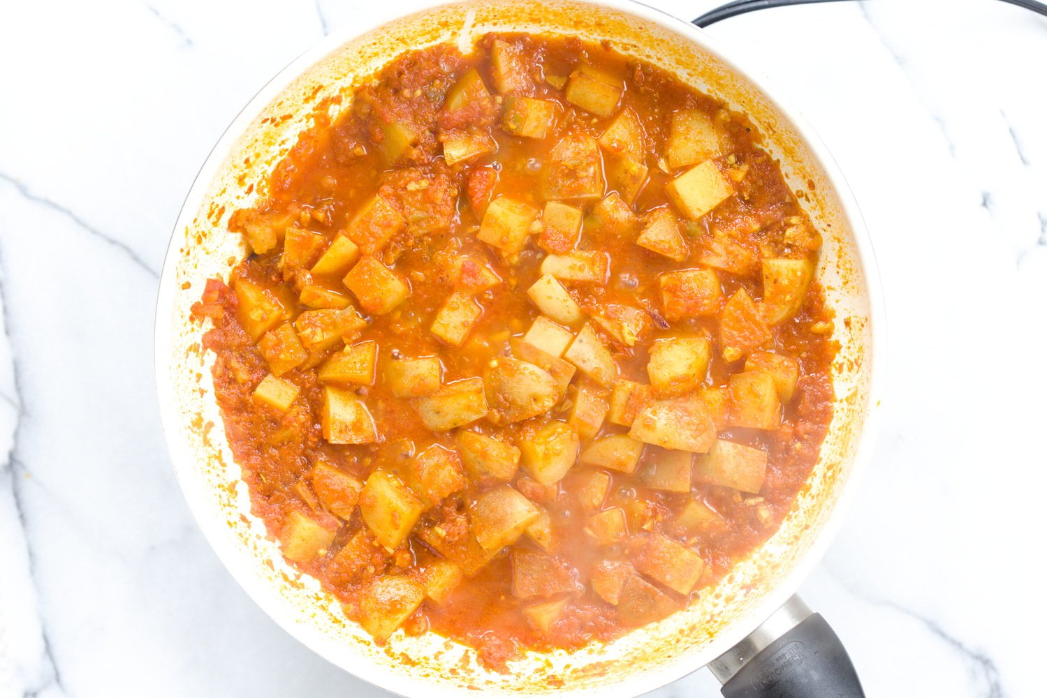 aloo matar aloo matar simmering in a white skillet