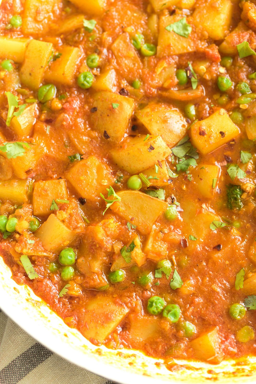 aloo matar close-up of a skillet with healthy vegan Indian aloo matar simmering