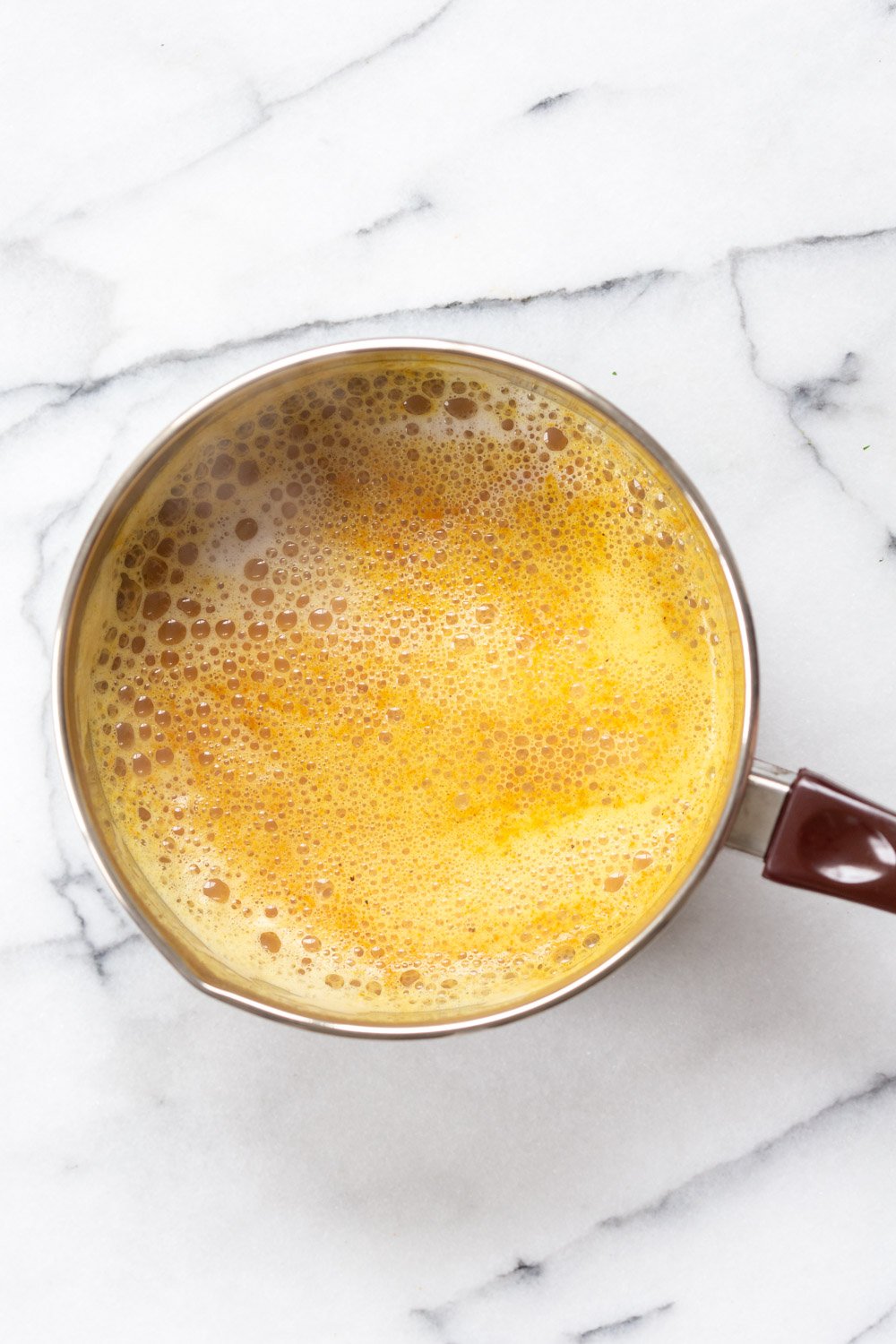 Turmeric Chai latte in a saucepan made with our Golden Chai Mix
