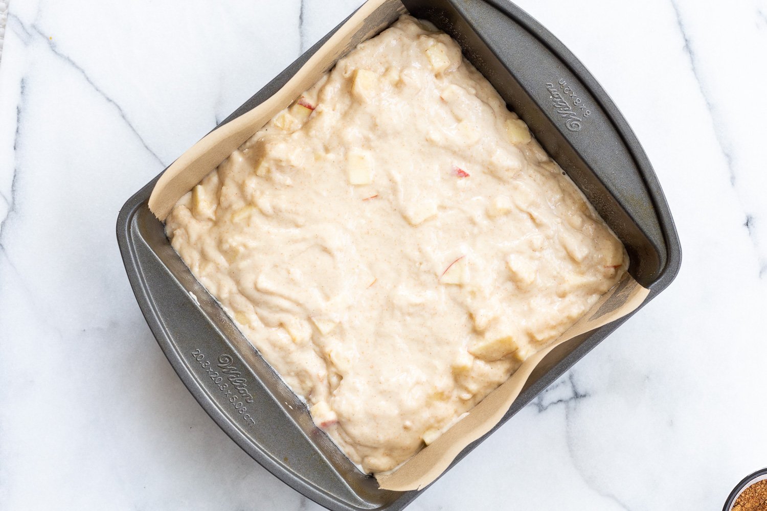 Vegan Apple Cake batter in parchment lined pan