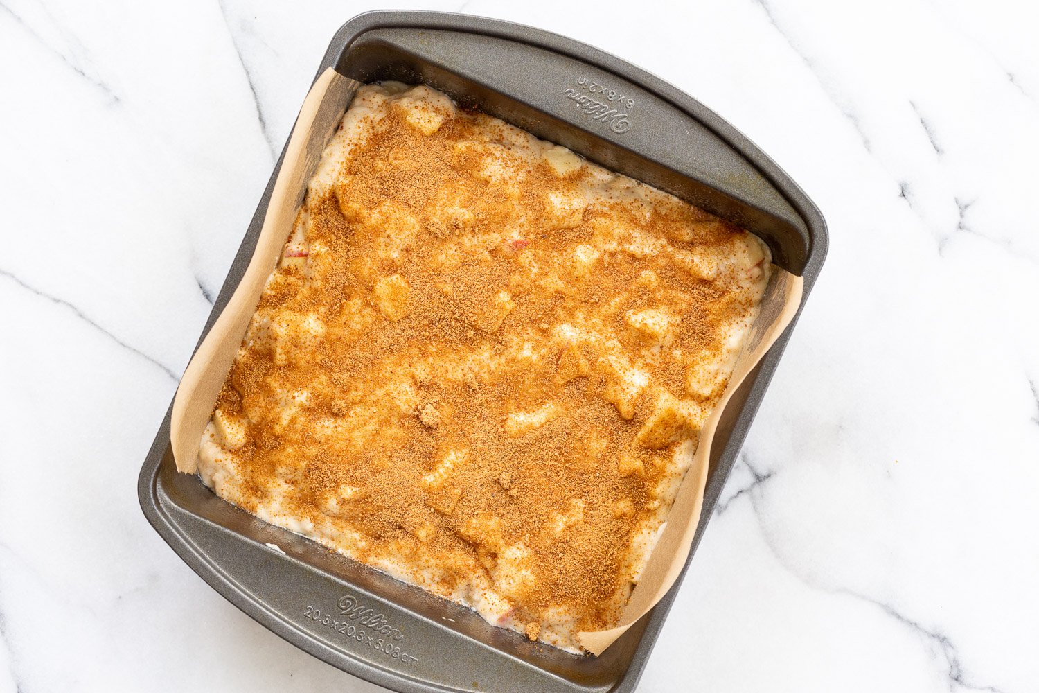 Vegan Apple Cake Batter topped with coconut sugar in cake pan