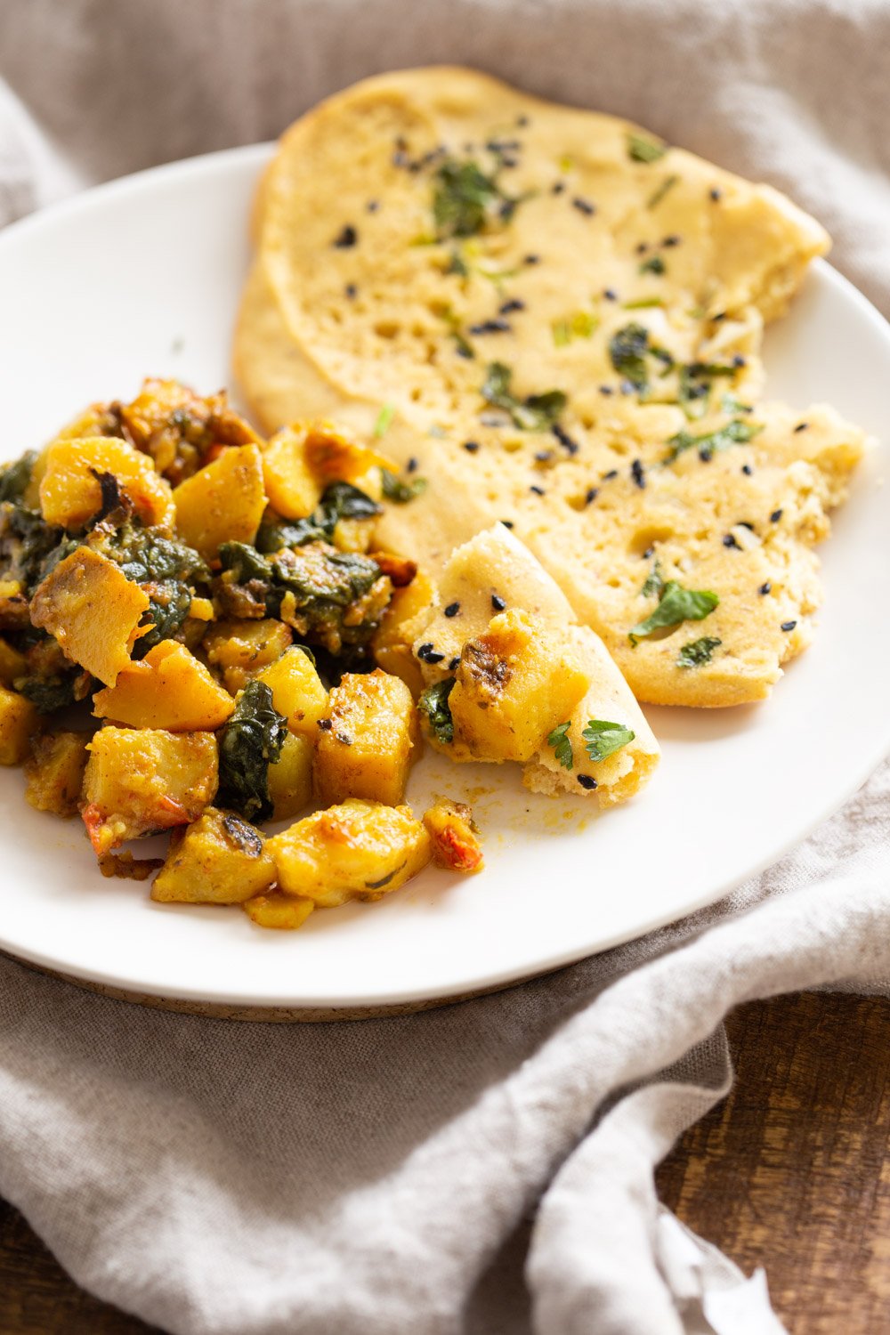Our Vegan Grain free Gluten Free Naan in a plate with potato spinach stir fry