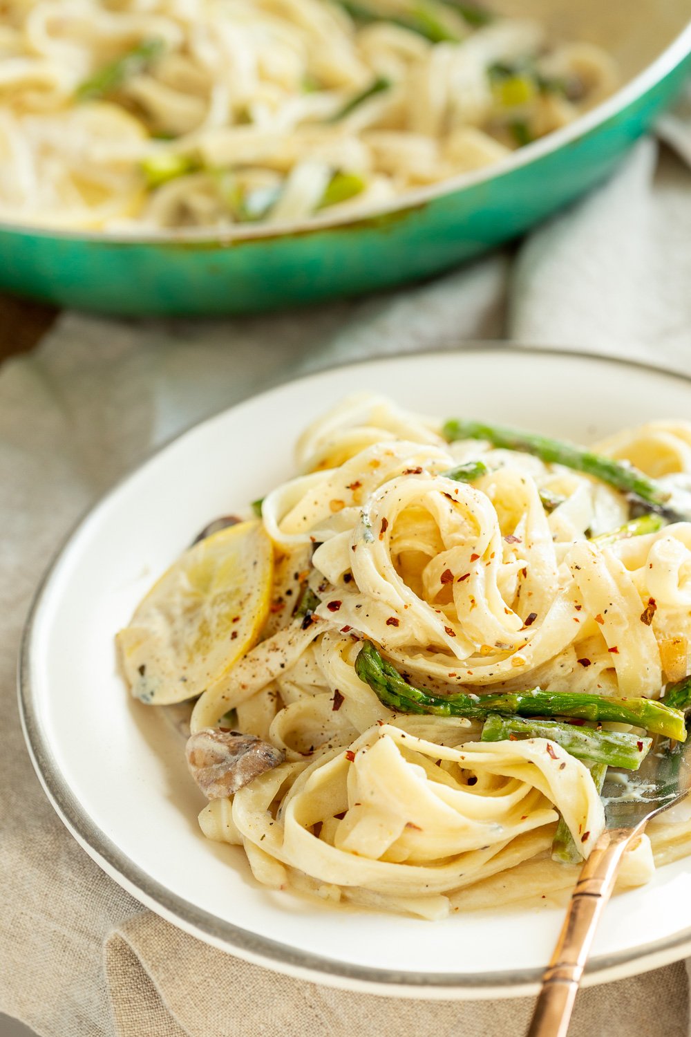Vegan Lemon Asparagus Pasta plated on a white plate kept over linen napkin #Veganricha