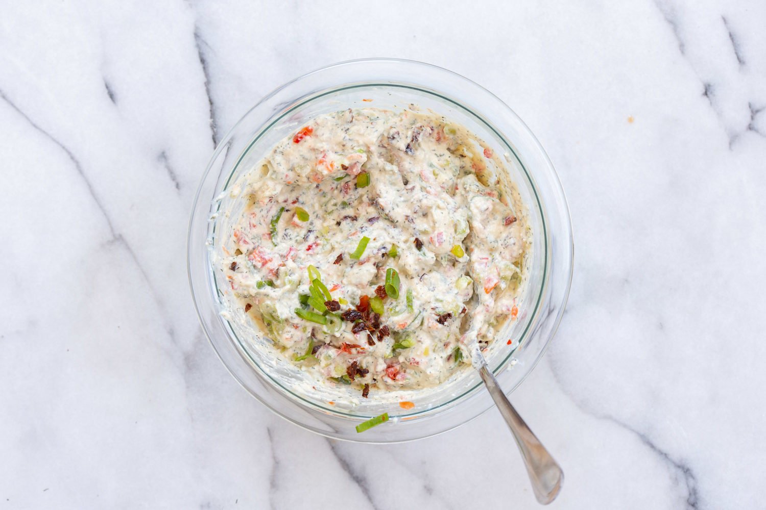 Dairy free cream cheese mixed with veggies in a bowl for our Vegan Tortilla Roll ups recipe