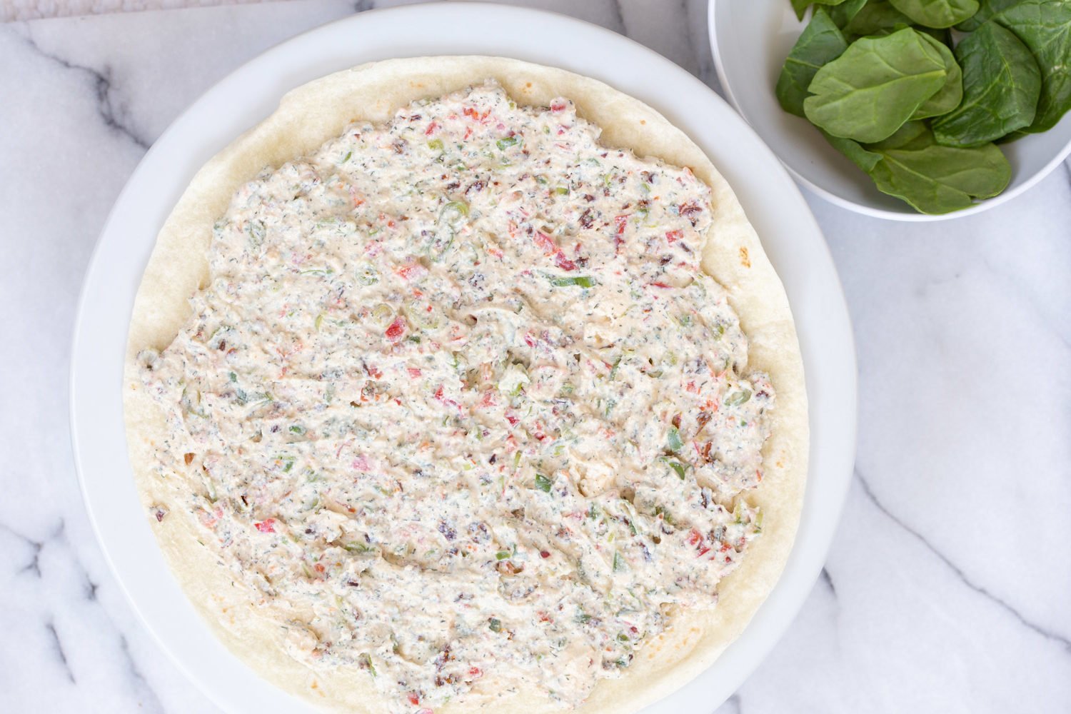 Dairy free Veggie Cream Cheese spread on tortilla for our Vegan Tortilla Roll ups recipe
