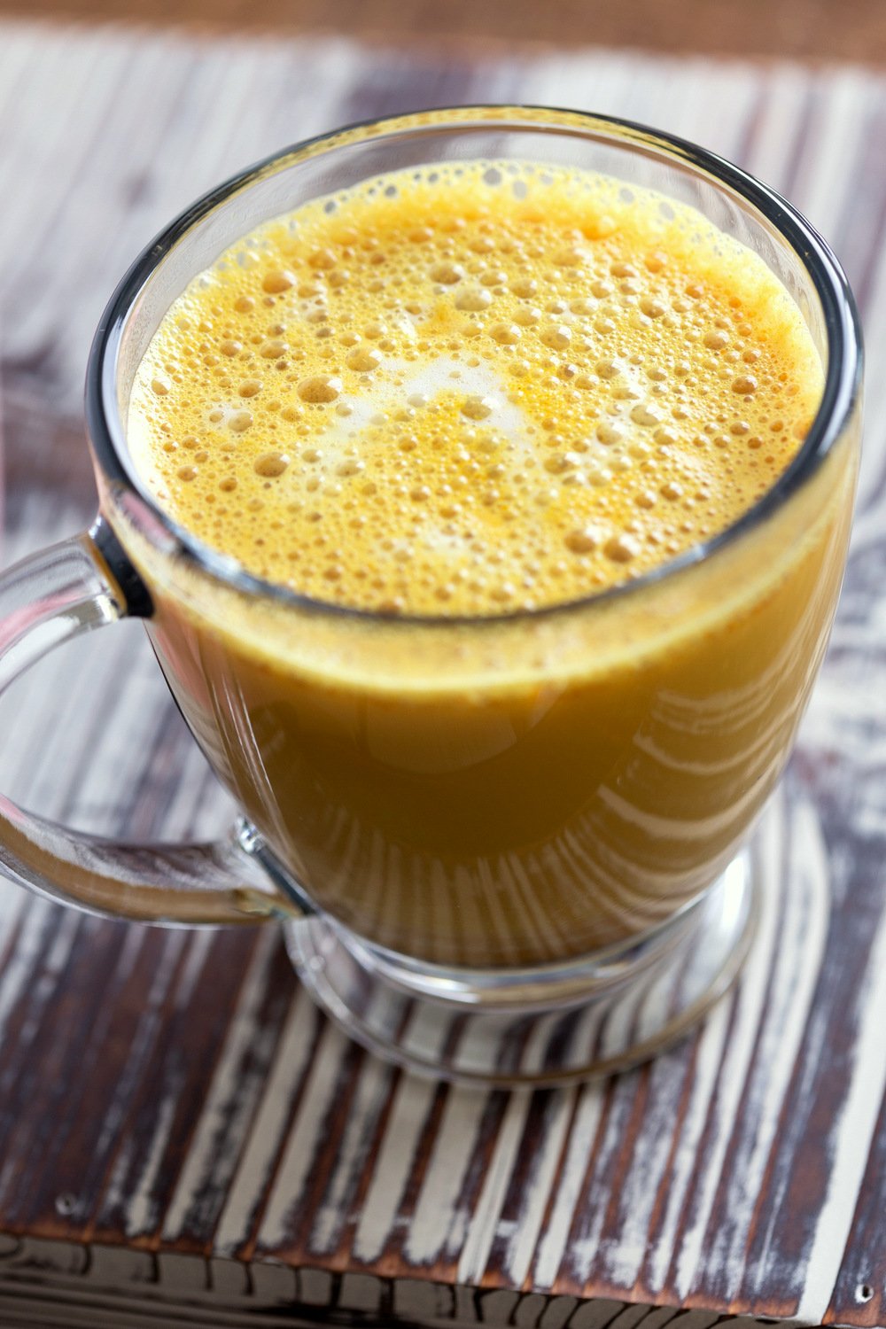 Golden Chai Latte made with our golden chai mix and almond milk in a glass cup
