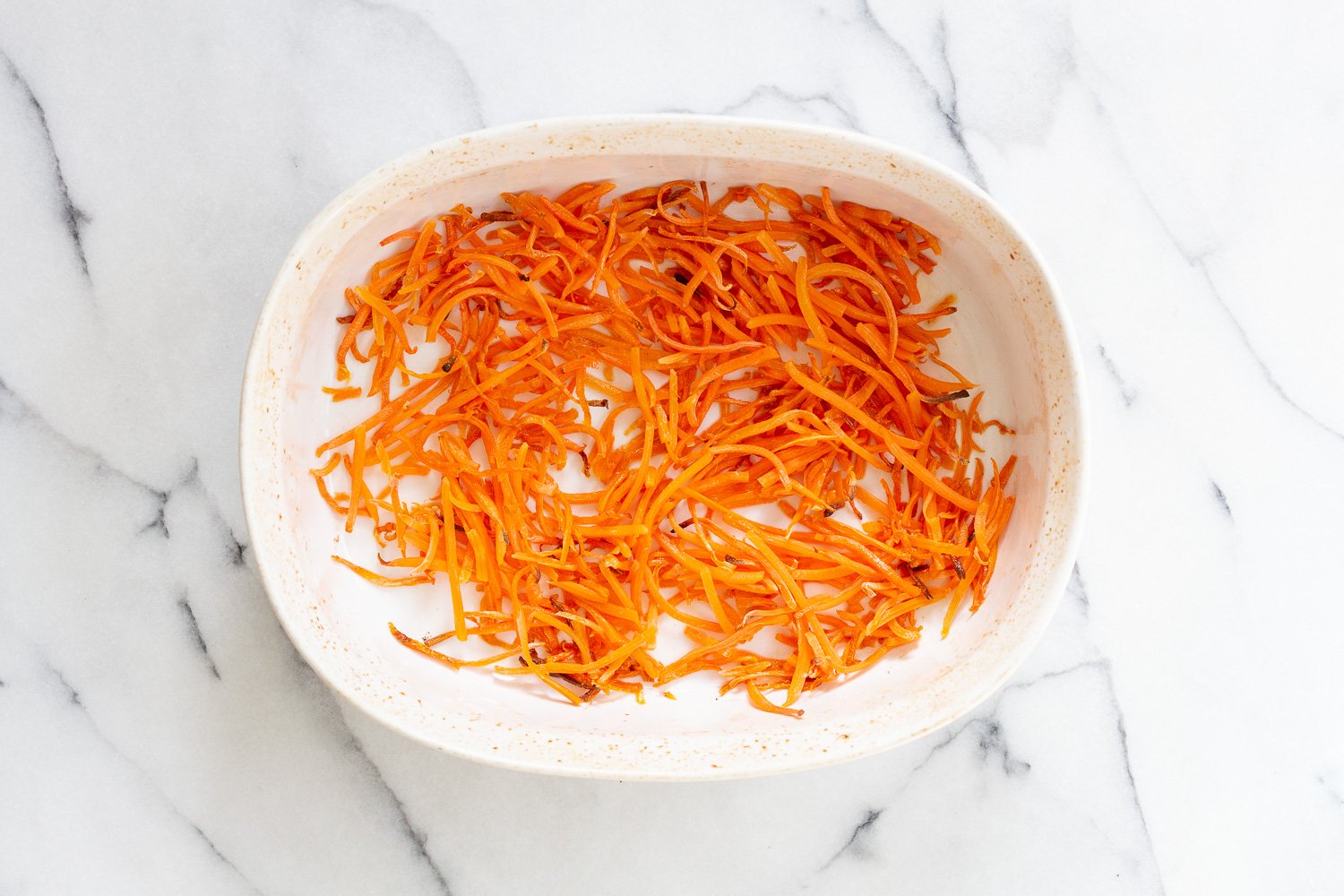 Roasted Carrots for our Vegan Carrot Cake Baked Oatmeal in a white baking dish