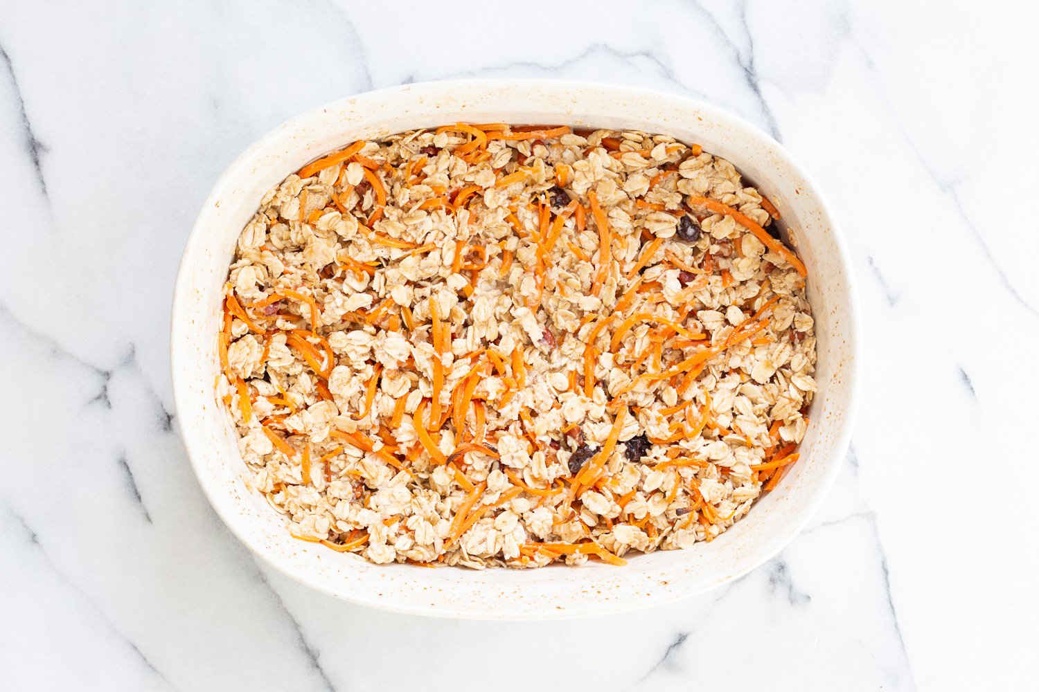 Our Vegan Carrot Cake Baked Oatmeal ready tobake in a white baking dish