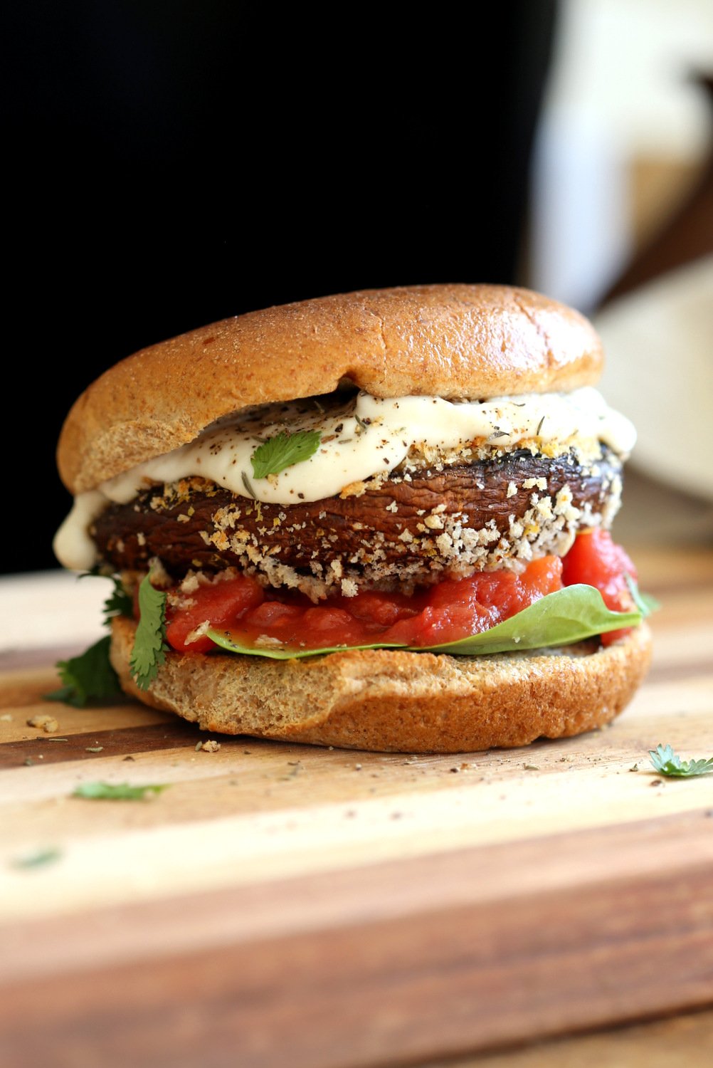Our Vegan Portobello Mushroom Burger on a wood board against black background