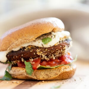 Vegan Portobello Mushroom Burger. Portobello marinated and stuffed with vegan mozzarella, then breaded to make Crispy Portobello Sandwiches! Top with more vegan mozzarella cream, fresh herbs. #Vegan #Recipe #VeganRicha #VeganPortobelloMushroomBurger #breadedportobello. Nutfree Gluten-free options