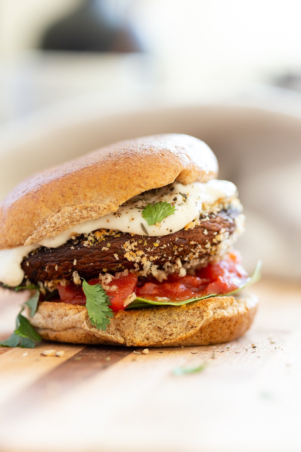Vegan Portobello Mushroom Burger. Portobello marinated and stuffed with vegan mozzarella, then breaded to make Crispy Portobello Sandwiches! Top with more vegan mozzarella cream, fresh herbs. #Vegan #Recipe #VeganRicha #VeganPortobelloMushroomBurger #breadedportobello. Nutfree Gluten-free options