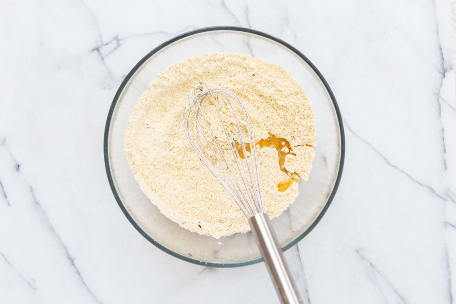 Chickpea flour and oil in a glass bowl for our Vegan Socca