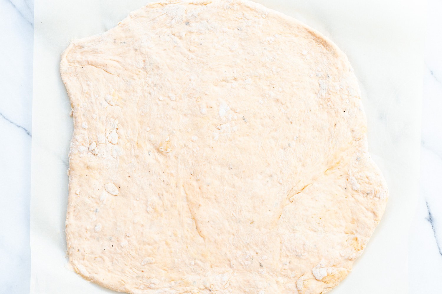 Vegan Pizza Rolls dough rolled out on parchment