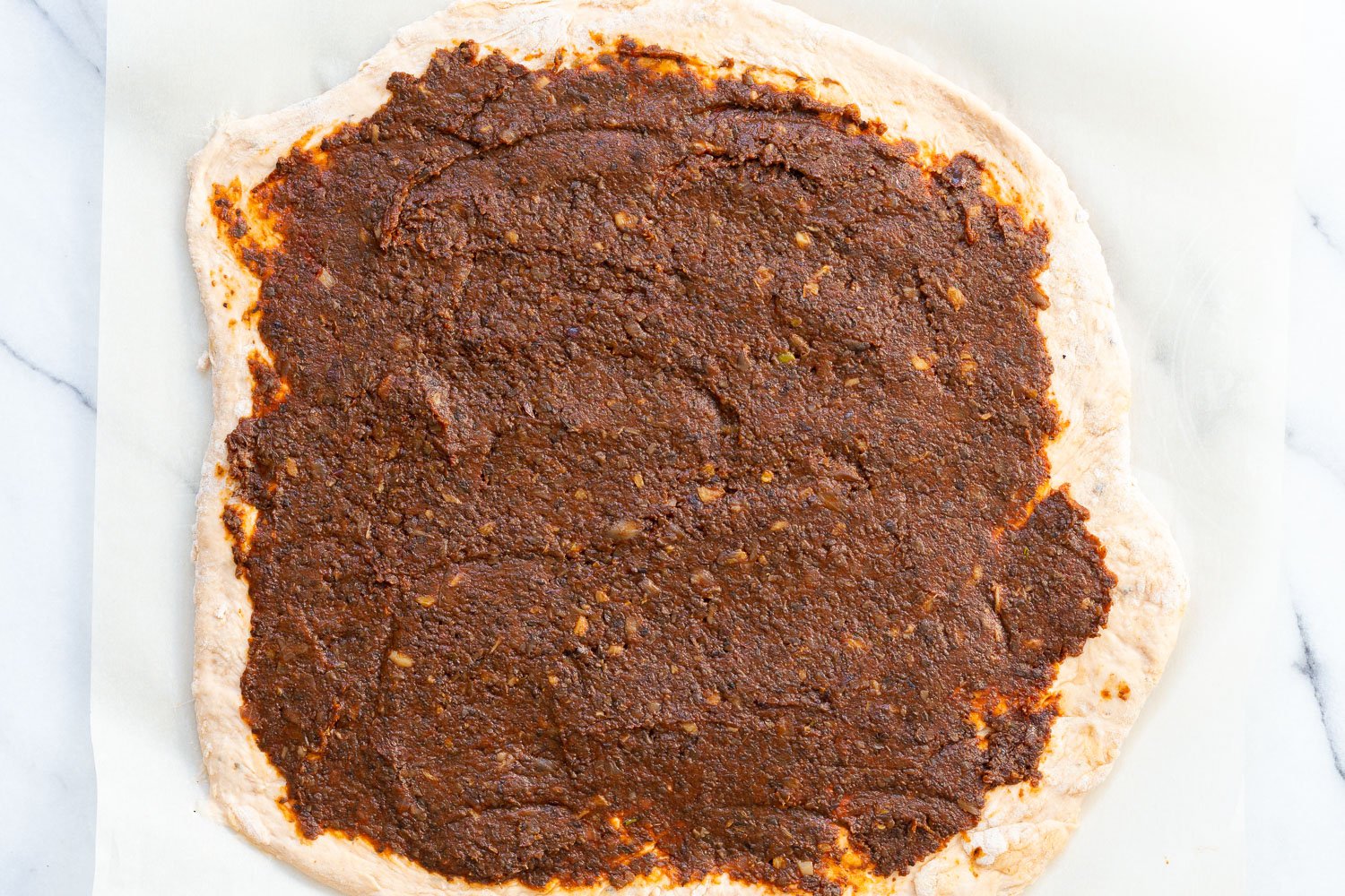 Filling spread on dough for our Vegan Pizza Rolls