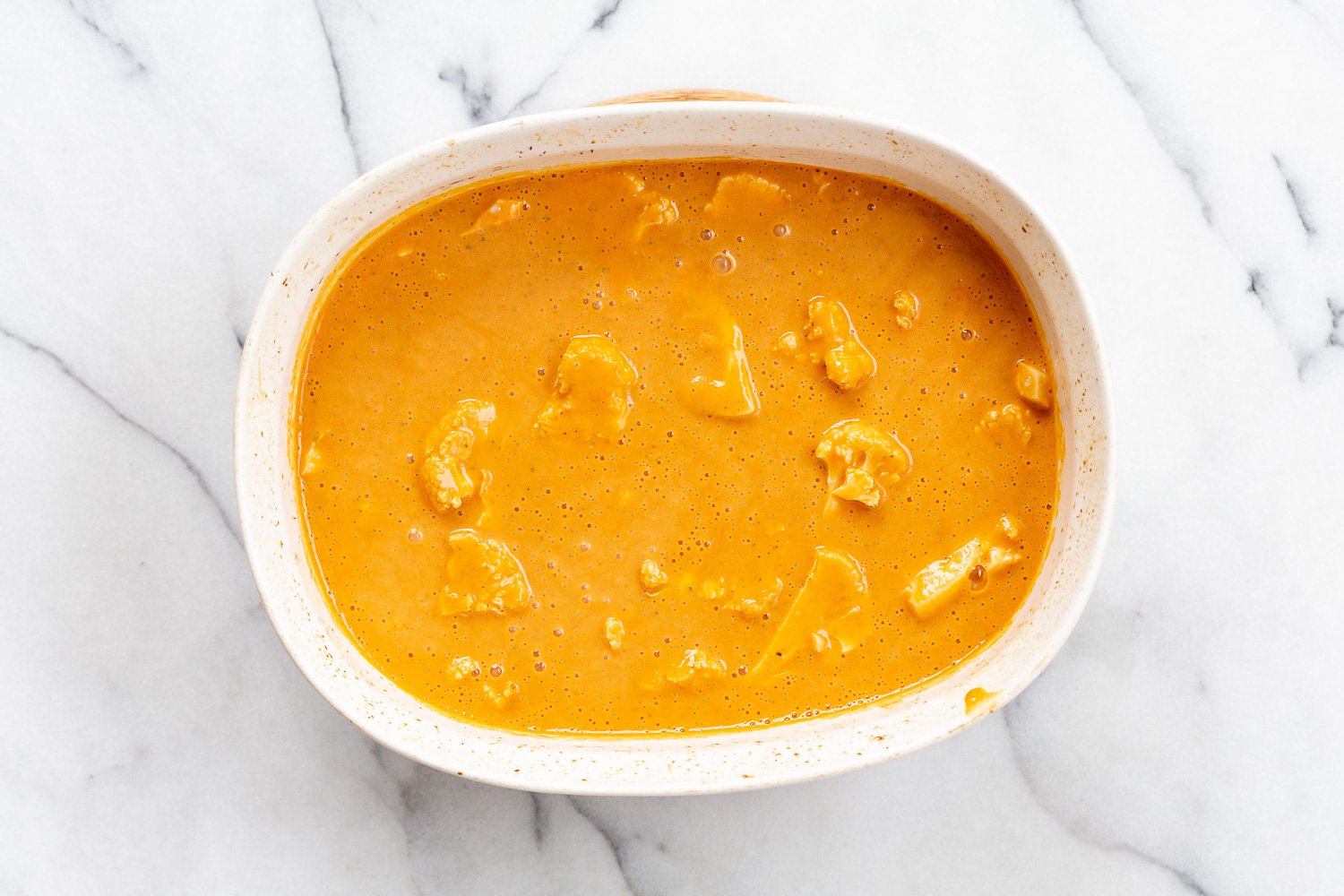 Sauce added to the baking dish for our Vegan Cauliflower Pea Curry