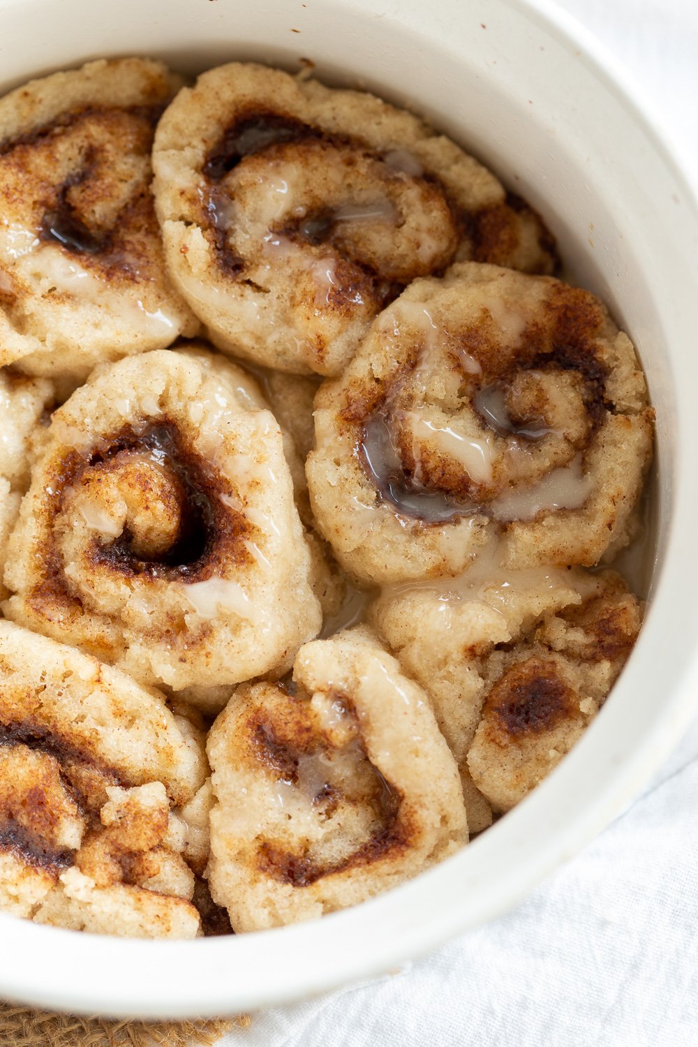 Our Vegan Gluten free Cinnamon rolls in a stoneware dish on marble