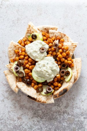 Vegan Mediterranean Nachos with Shawarma Chickpeas, Tzatziki, Olives, Cucumber, warm toasted Pita bread. Great Appetizer for parties or potluck. #Vegan #Veganricha #Mediterraneannachos