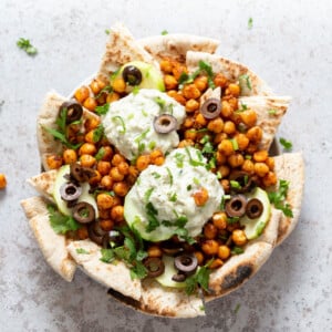 Mediterranean Nachos with Shawarma Chickpeas, Tzatziki, Olives, Cucumber, warm toasted Pita bread. Great Appetizer for parties or potluck. #Vegan #Veganricha #Mediterraneannachos