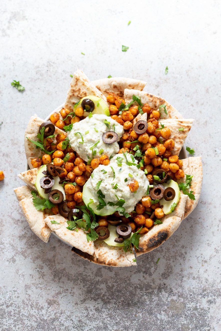 Vegan Mediterranean Nachos on a white plate on concrete