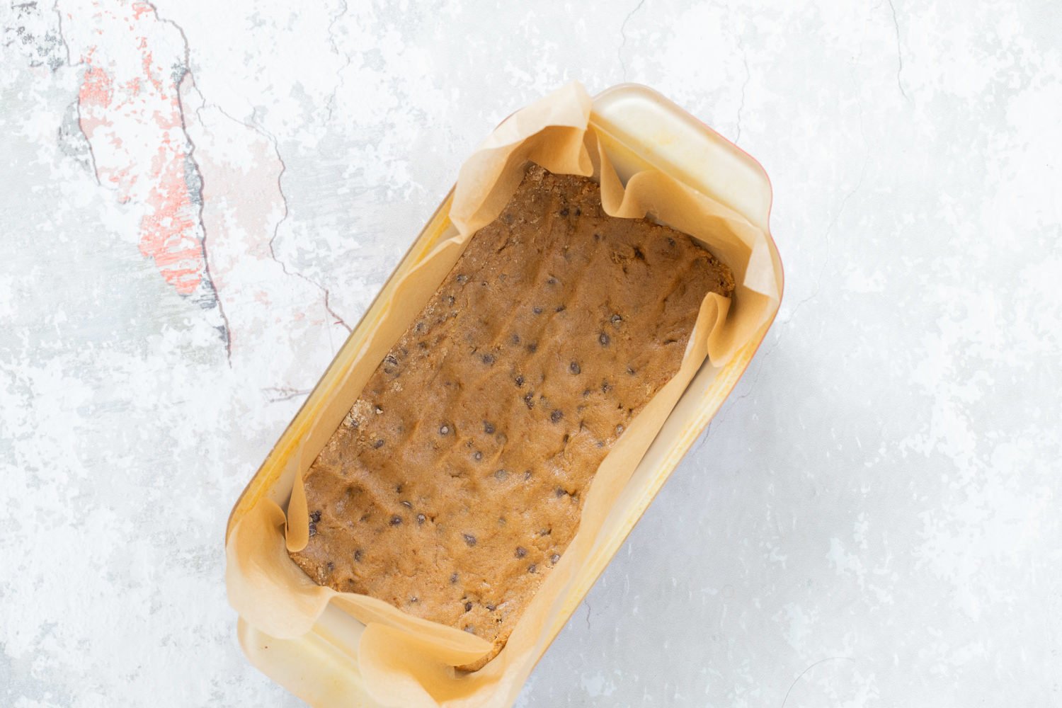 Cookie dough layer in a baking pan for our Vegan Cookie Dough Ice Cream Sandwiches