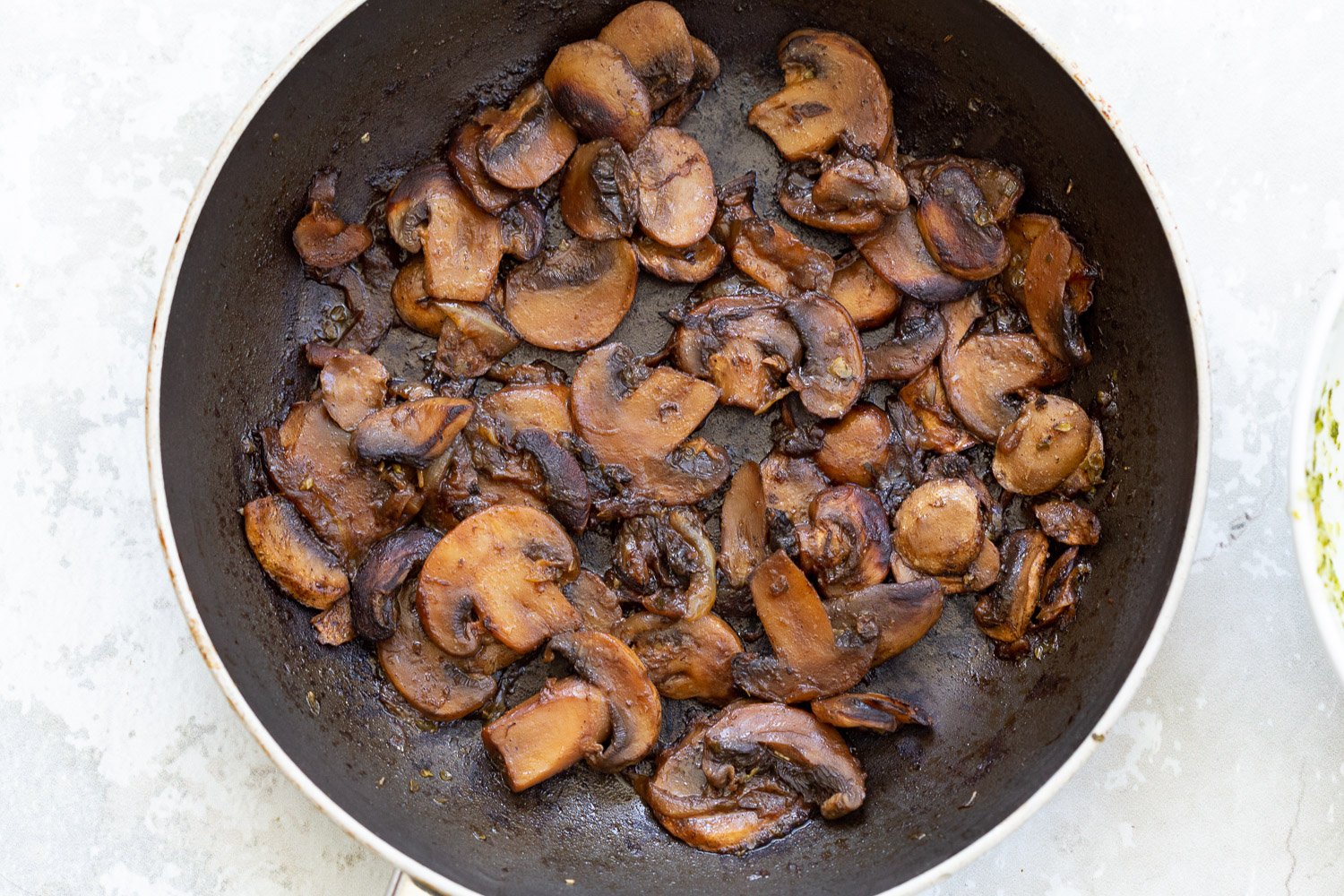 pizza rolls recipe  mushrooms sauteeing in a black pan
