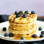 Our Easy Vegan Waffles stacked on a white plate over black napkin