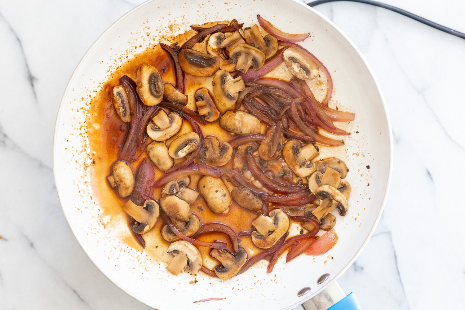 Onion and Mushroom cooked in a white skillet for our Vegan Mushroom Quesadilla