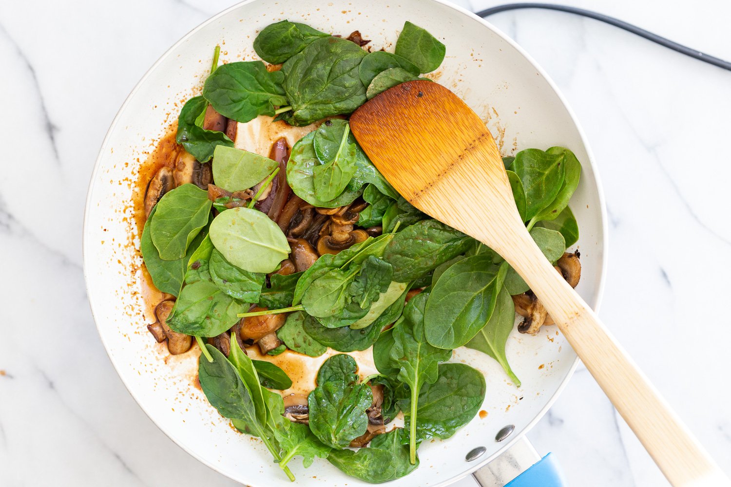 Onion, Mushroom, spinach cooked in a white skillet for our Vegan Mushroom Quesadilla