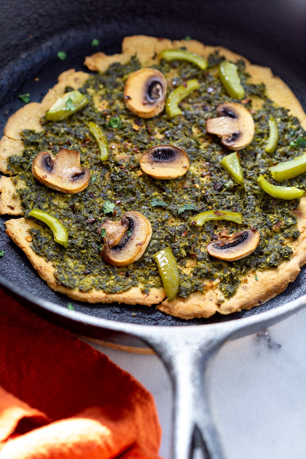 Socca Pizza with chimichurri and mushrooms on cast iron skillet